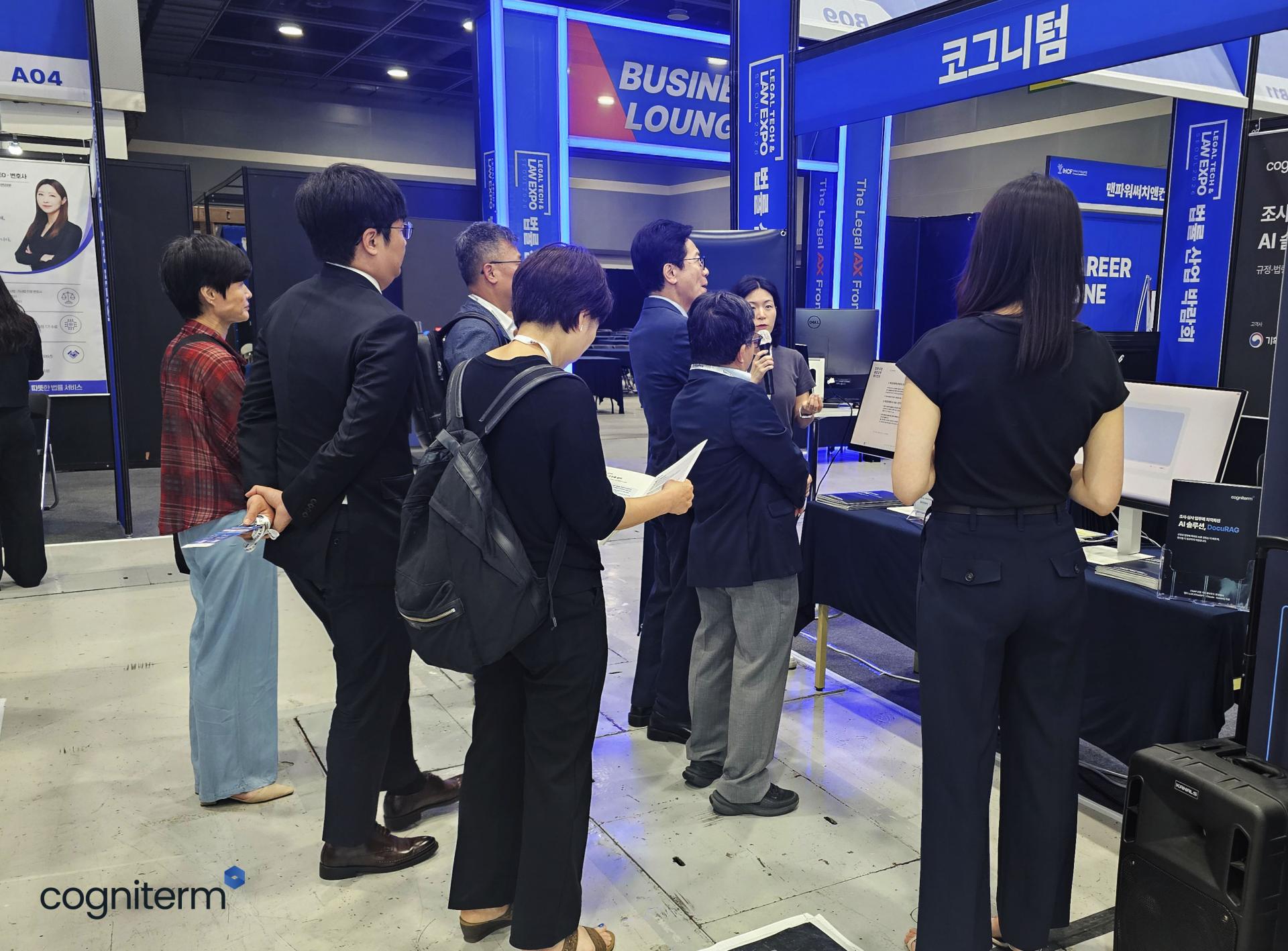 2026 대한민국 법률 산업 박람회 코그니텀 부스에서 관람객들이 DocuRAG 시연 설명을 듣고 있다